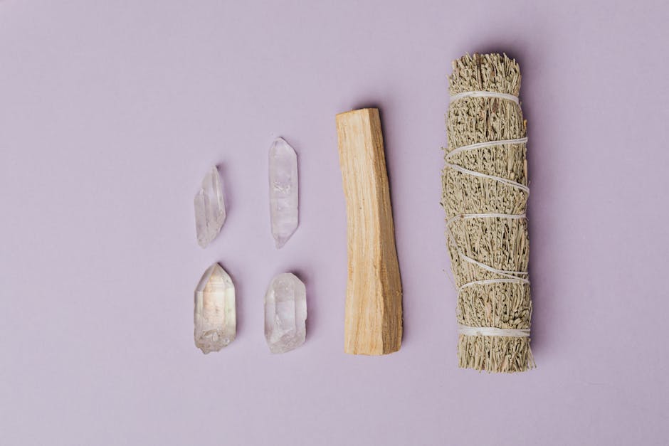 Flat lay of healing crystals and sage smudge stick for spiritual cleansing.